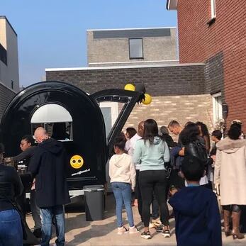 Buurtbewoners verzamelen bij de truck in een nieuwbouwwijk
