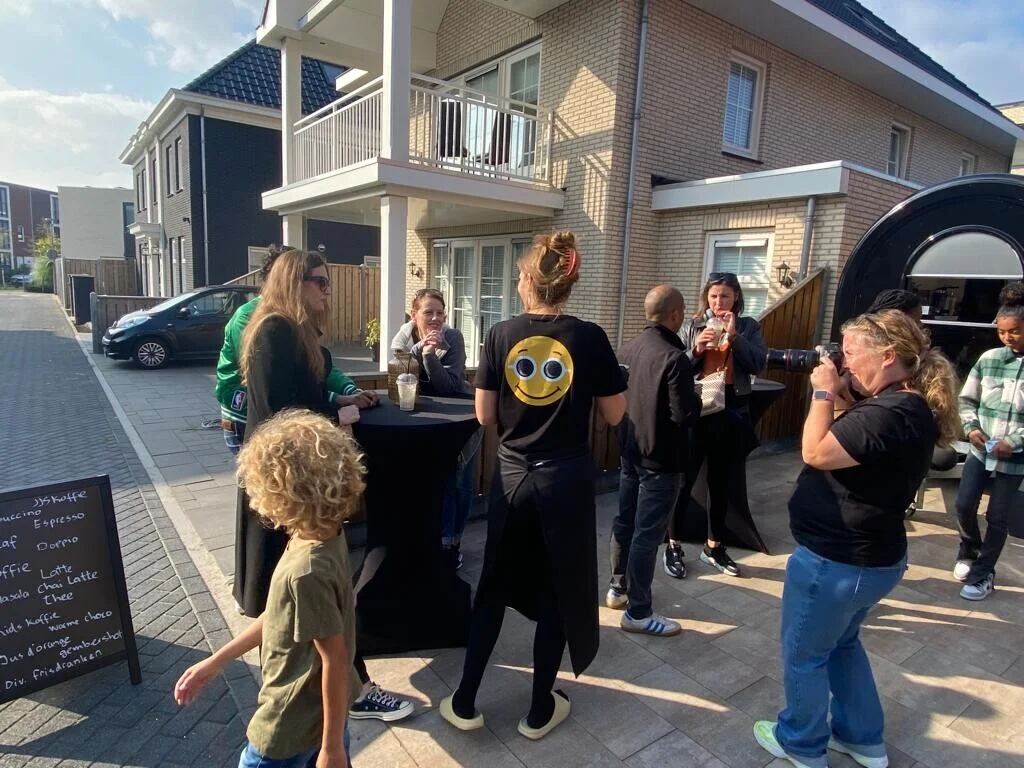 Bediening met Coffee Mati-schort aan een statafel in de wijk