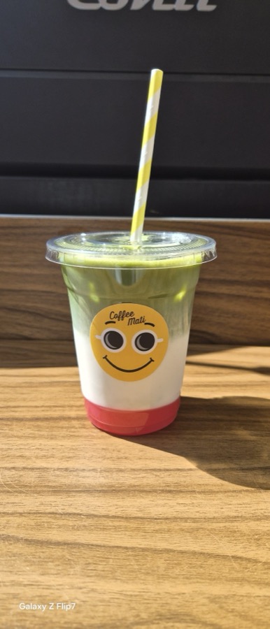 IJskoude matcha met een gestreept rietje in een Coffee Mati-beker